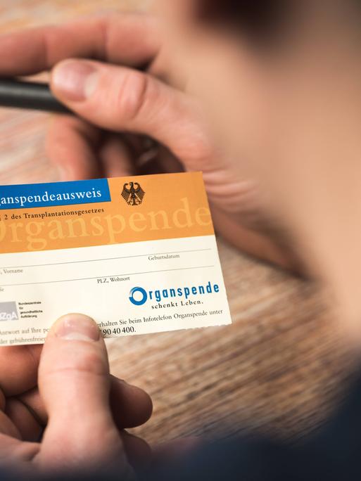 Ein Mann füllt einen Organspendeausweis aus