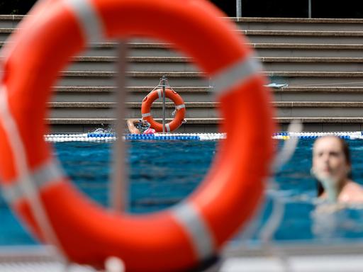 Rettungsringe hängen am Rand eines Schwimmbads.