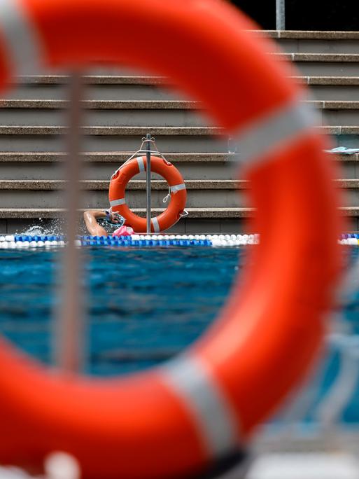 Rettungsringe hängen am Rand eines Schwimmbads.