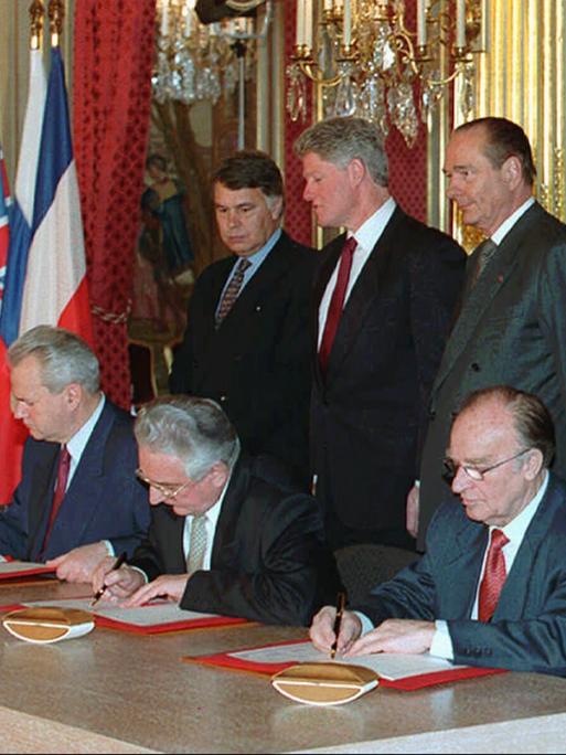 Unterzeichnung des Dayton-Abkommens 1995 durch führende Politiker von Serbien, Kroatien und Bosnien im Beisein mehrerer westlicher Staats- und Regierungschefs, unter ihnen US-Präsident Clinton und Bundeskanzler Kohl.