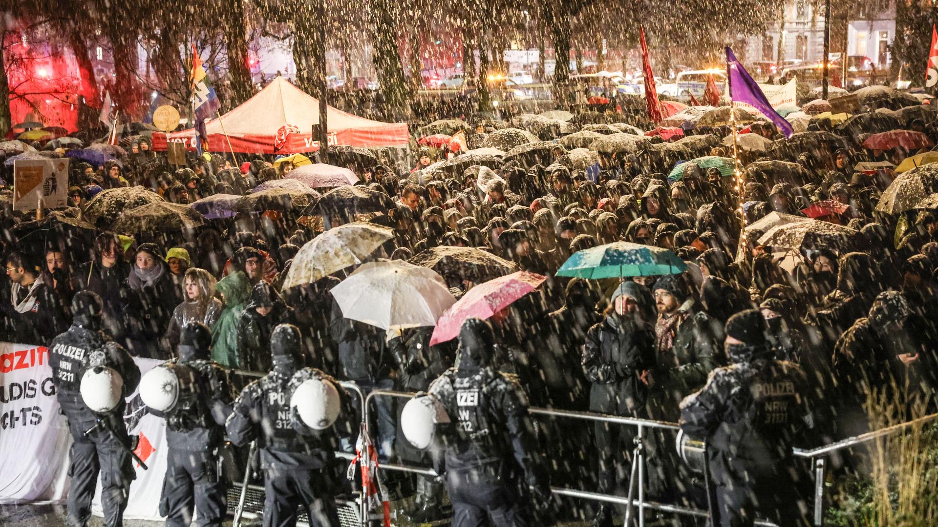 Demonstranten stehen an einem Absperrgitter. Demonstranten stehen an einem Absperrgitter.