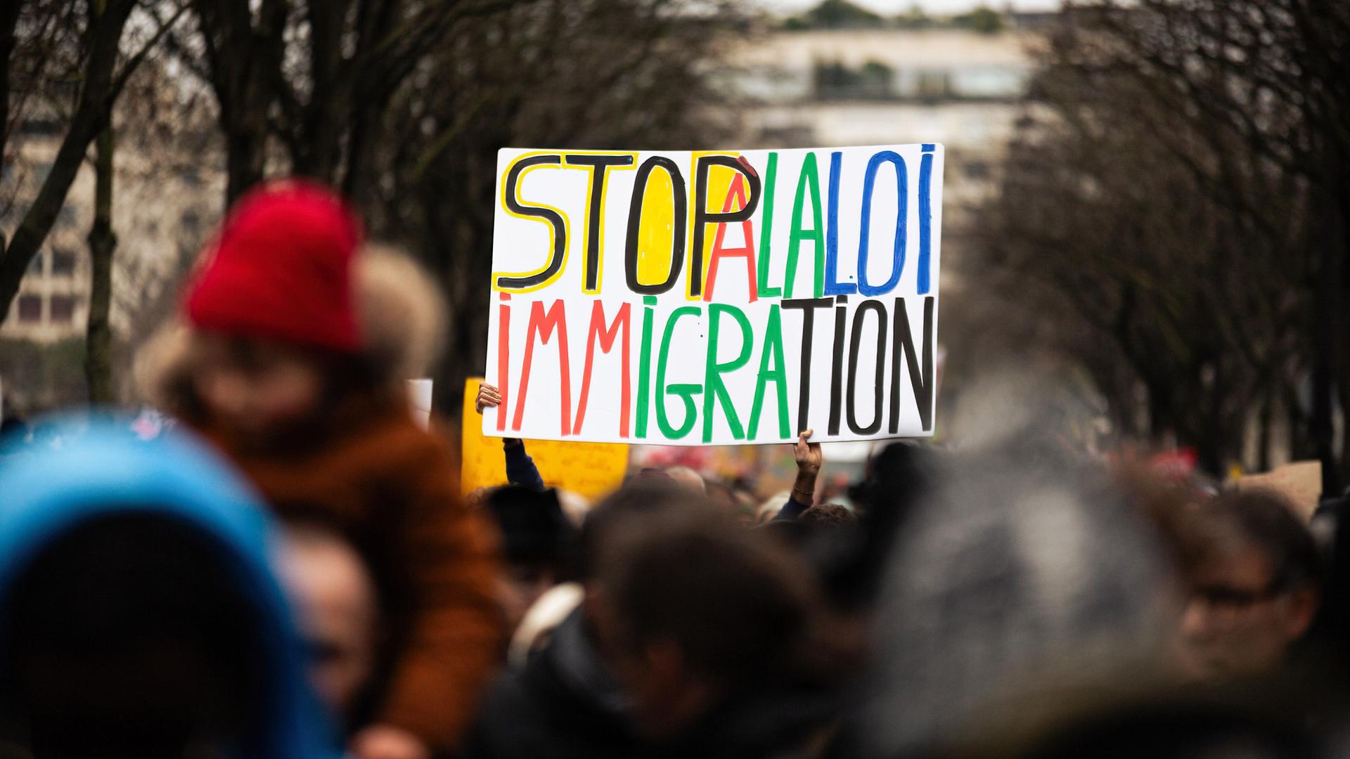 Ein großes Plakat mit der Aufschrift "Stop à la loi immigration" (etwa: Stoppt das Einwanderungsgesetz) bei einer Demonstration in Frankreich. Ein großes Plakat mit der Aufschrift "Stop à la loi immigration" (etwa: Stoppt das Einwanderungsgesetz) bei einer Demonstration in Frankreich.