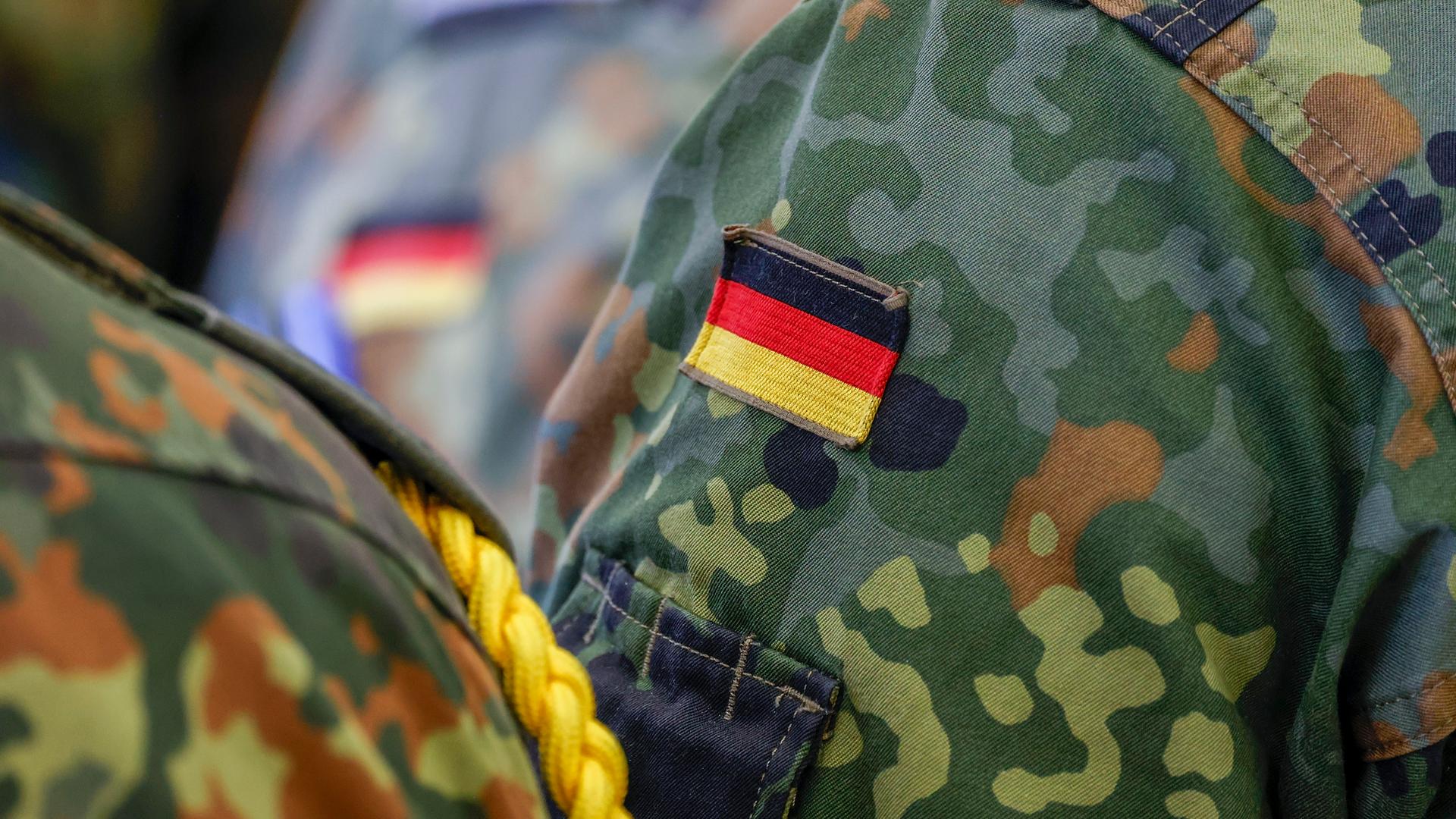 Nahaufnahme der Uniform eines Bundeswehrsoldaten, auf dem eine deutsche Nationalflagge zu sehen ist. 