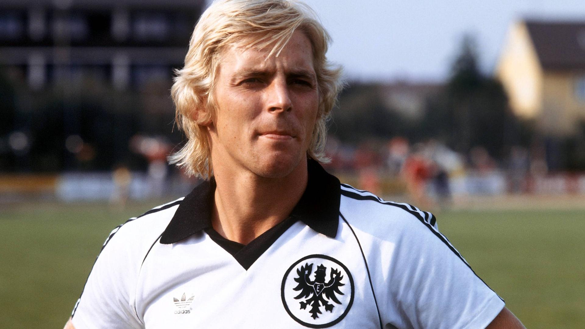 Norbert Nachtweih steht 1980 im Eintracht Frankfurt Trikot auf dem Fußballplatz.