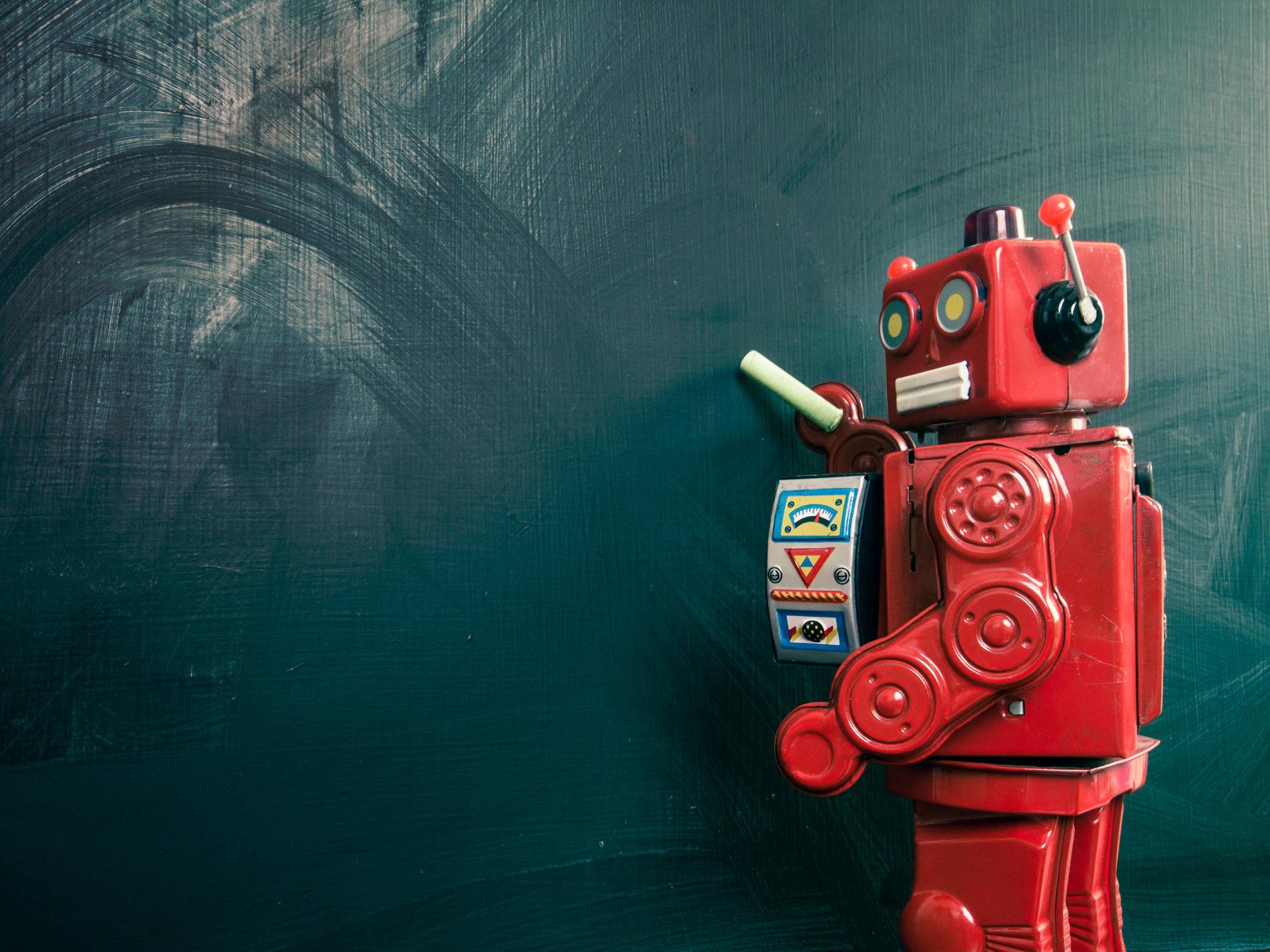 Roboter mit Kreide an einer leeren Tafel