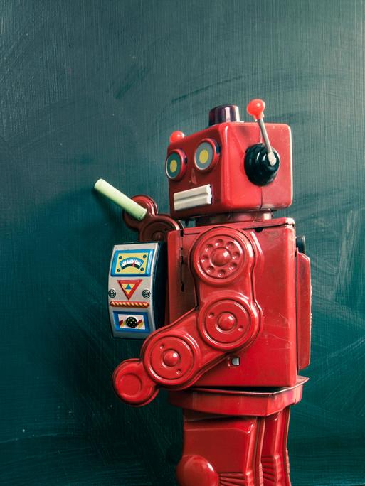 Roboter mit Kreide an einer leeren Tafel