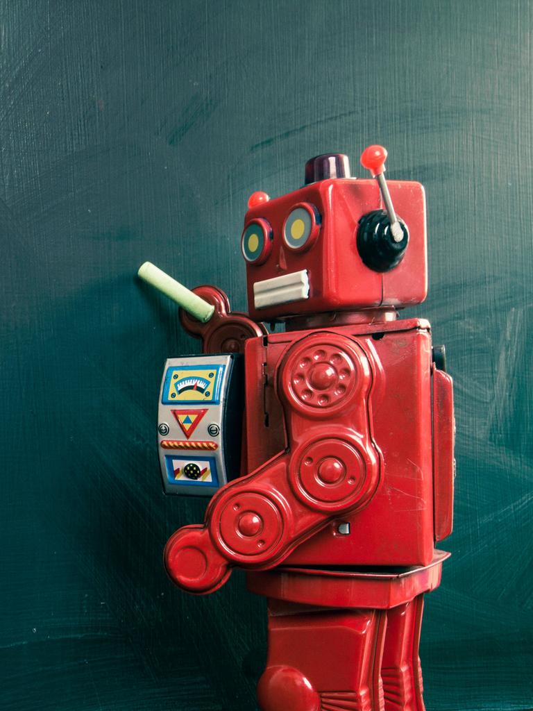 Roboter mit Kreide an einer leeren Tafel
