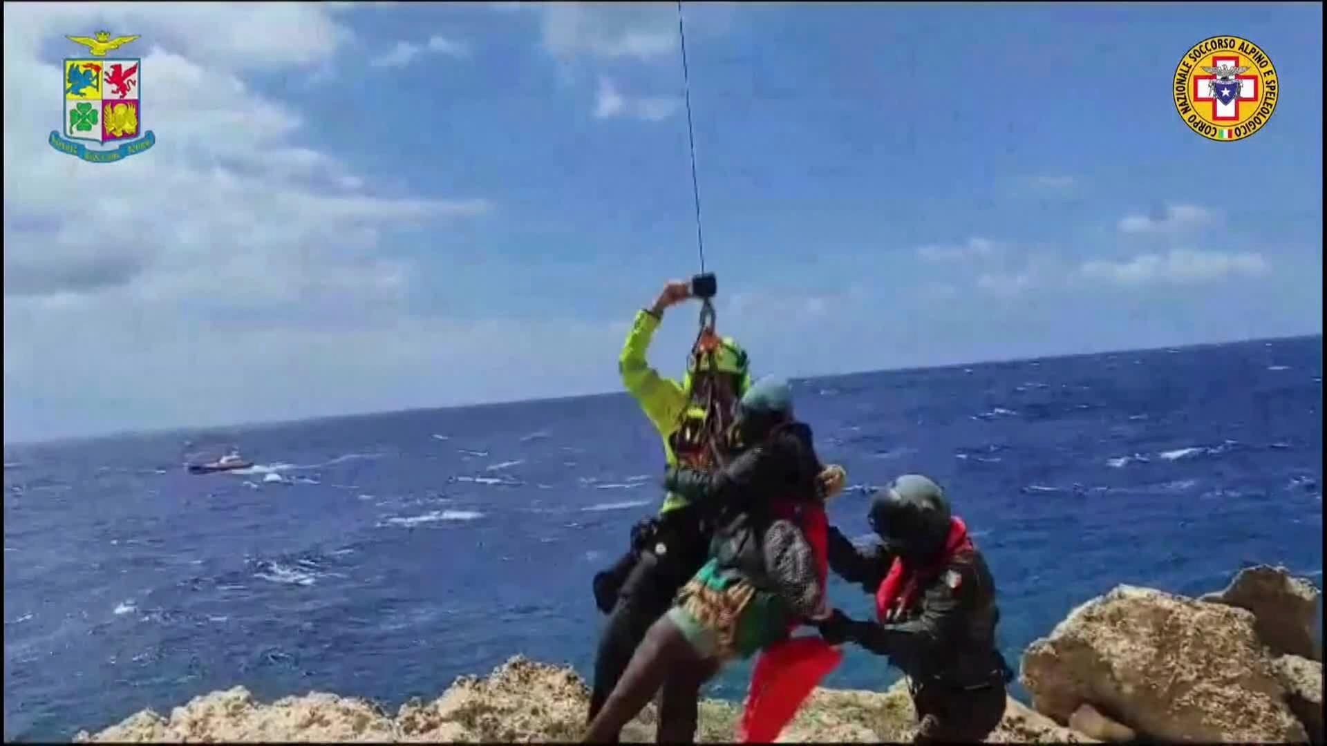 Italien, Lampedusa: Dieses von der italienischen Bergwacht zur Verfügung gestellte Videostandbild zeigt eine Person, die auf einem Felsenriff gestrandet ist und von einem Hubschrauber in Sicherheit gebracht wird. Italien, Lampedusa: Dieses von der italienischen Bergwacht zur Verfügung gestellte Videostandbild zeigt eine Person, die auf einem Felsenriff gestrandet ist und von einem Hubschrauber in Sicherheit gebracht wird.