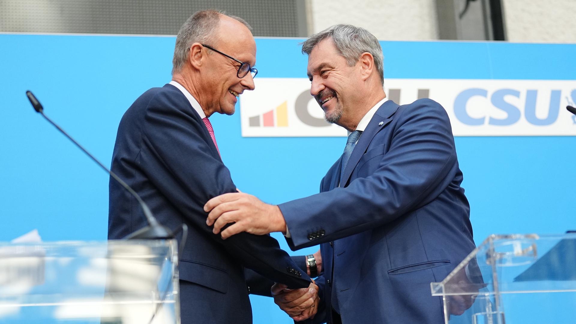 Friedrich Merz (l), CDU-Bundesvorsitzender und Unionsfraktionsvorsitzender, und Markus Söder, CSU-Vorsitzender und Ministerpräsident von Bayern, reichen sich die Hände. 