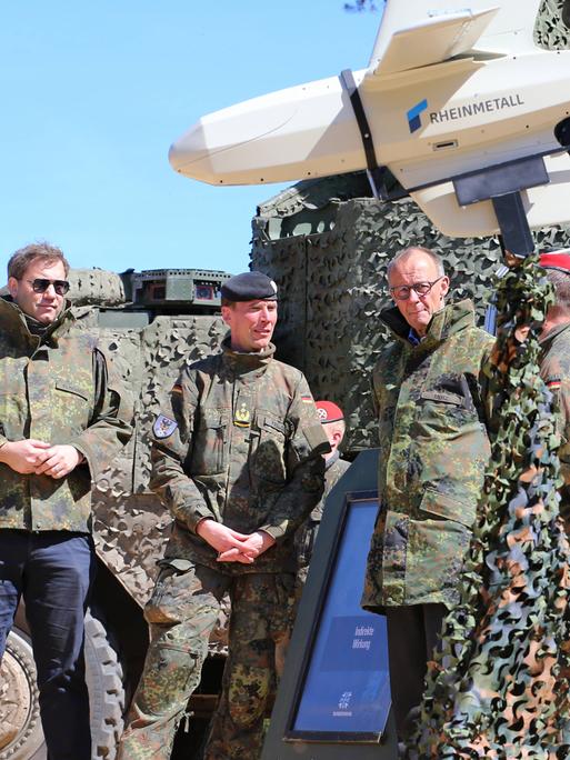 Bundeskanzler Merz und Vizekanzler Klingbeil werden vom Inspekteur des Heeres, Generalleutnant Christian Freudin über verschiedene Drohnen informiert. Links eine KI-gesteuerte XH-2-Drohne der Firma Helsing, rechts eine Drohne Raider FV-014 von Rheinmetall Bundeskanzler Merz und Vizekanzler Klingbeil werden vom Inspekteur des Heeres, Generalleutnant Christian Freudin über verschiedene Drohnen informiert. Links eine KI-gesteuerte XH-2-Drohne der Firma Helsing, rechts eine Drohne Raider FV-014 von Rheinmetall