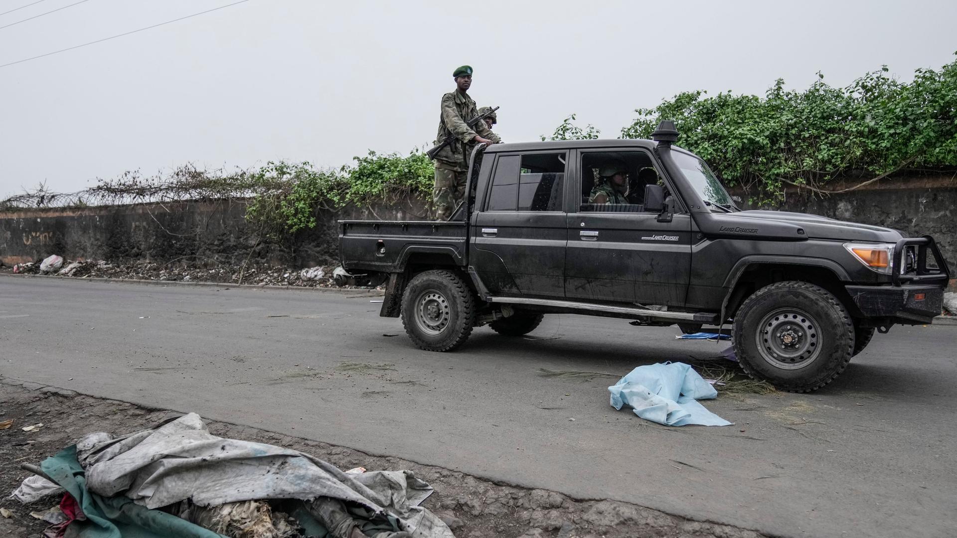 Mitglieder der M23 Rebellengruppe patrouillieren in einem Auto in Goma auf einer Straße.