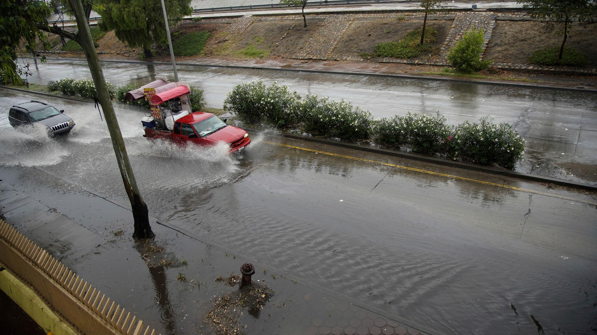 Autos fahren auf einer überfluteten Straße in Tijuana in Kalifornien.