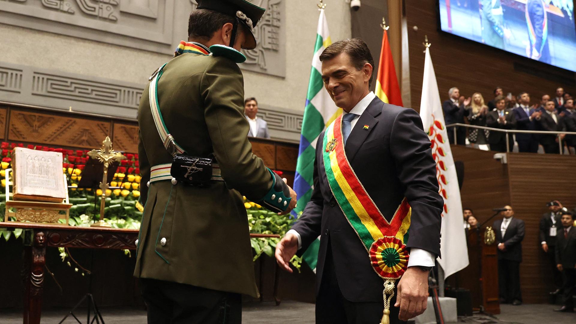 Das Bild zeigt Boliviens neuen Präsidenten Rodrigo Paz, der während seiner Amtseinführung von Vizepräsident Edman Lara die Präsidentenschärpe überreicht bekommt. Das Bild zeigt Boliviens neuen Präsidenten Rodrigo Paz, der während seiner Amtseinführung von Vizepräsident Edman Lara die Präsidentenschärpe überreicht bekommt.