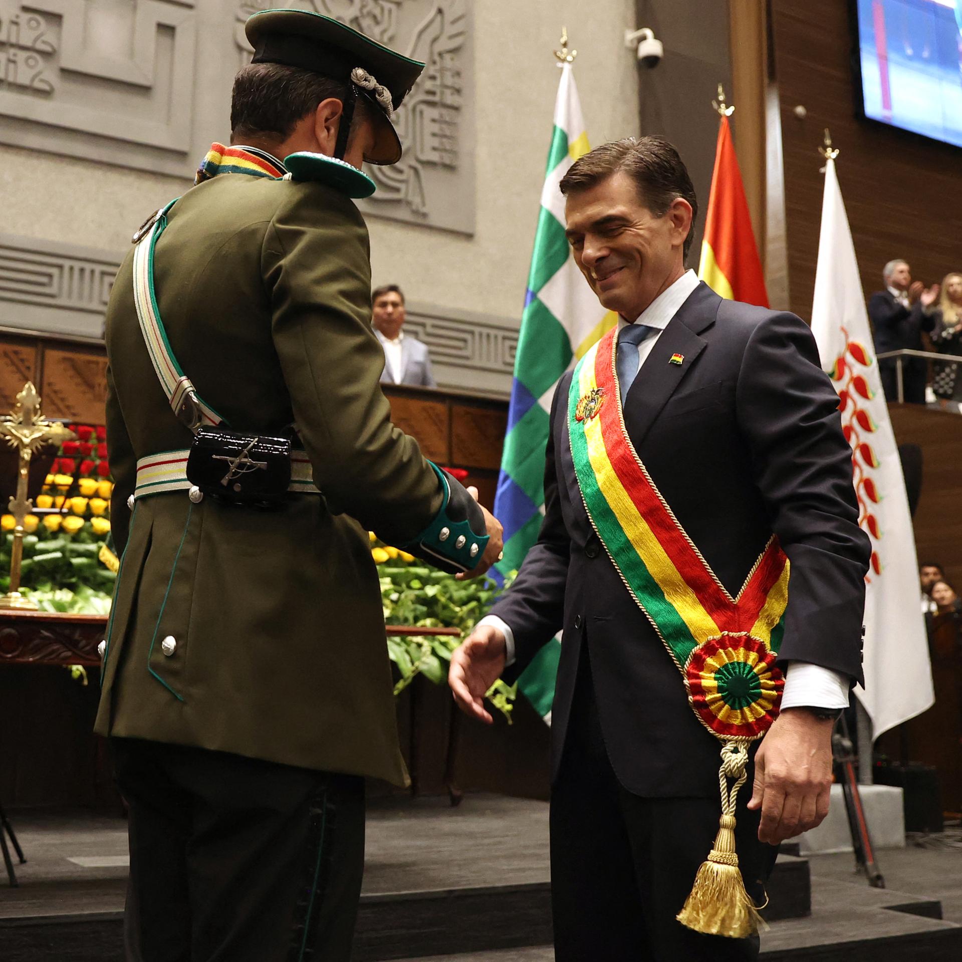 Das Bild zeigt Boliviens neuen Präsidenten Rodrigo Paz, der während seiner Amtseinführung von Vizepräsident Edman Lara die Präsidentenschärpe überreicht bekommt. 