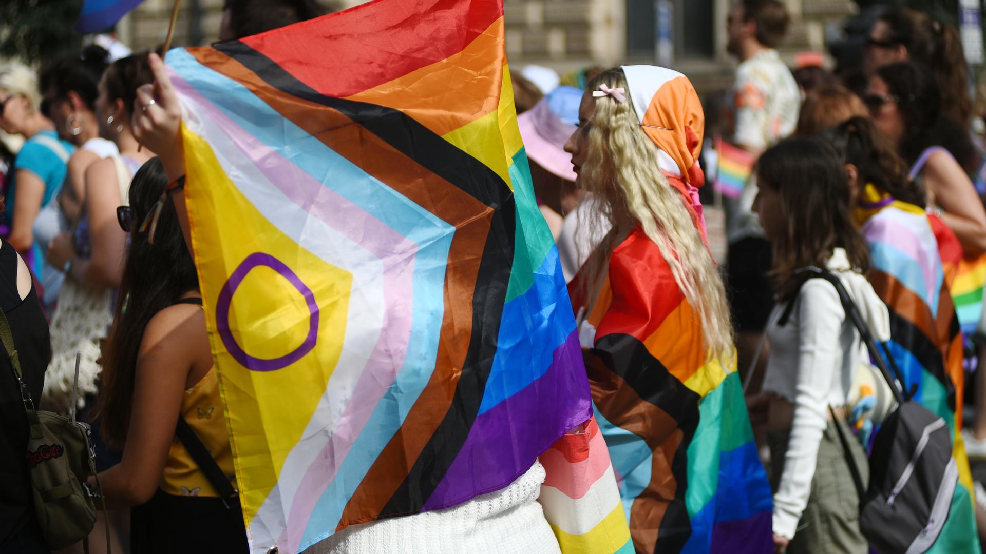Während Pride-Parade in Budapest trägt eine Demonstrantin eine Regenbogenfahne.