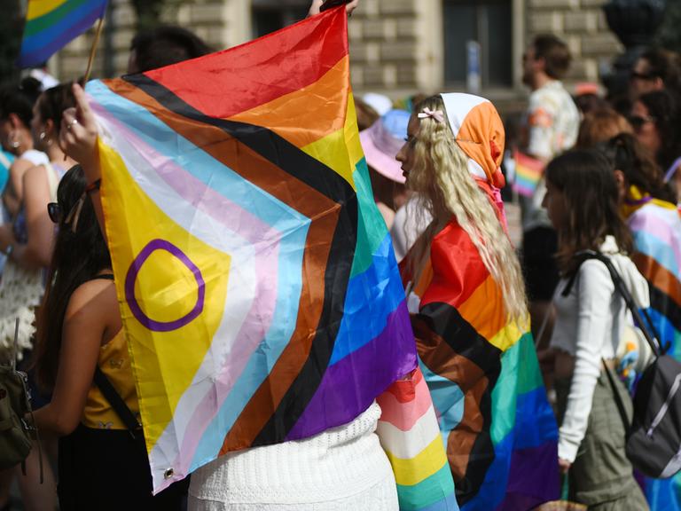 Während Pride-Parade in Budapest trägt eine Demonstrantin eine Regenbogenfahne.
