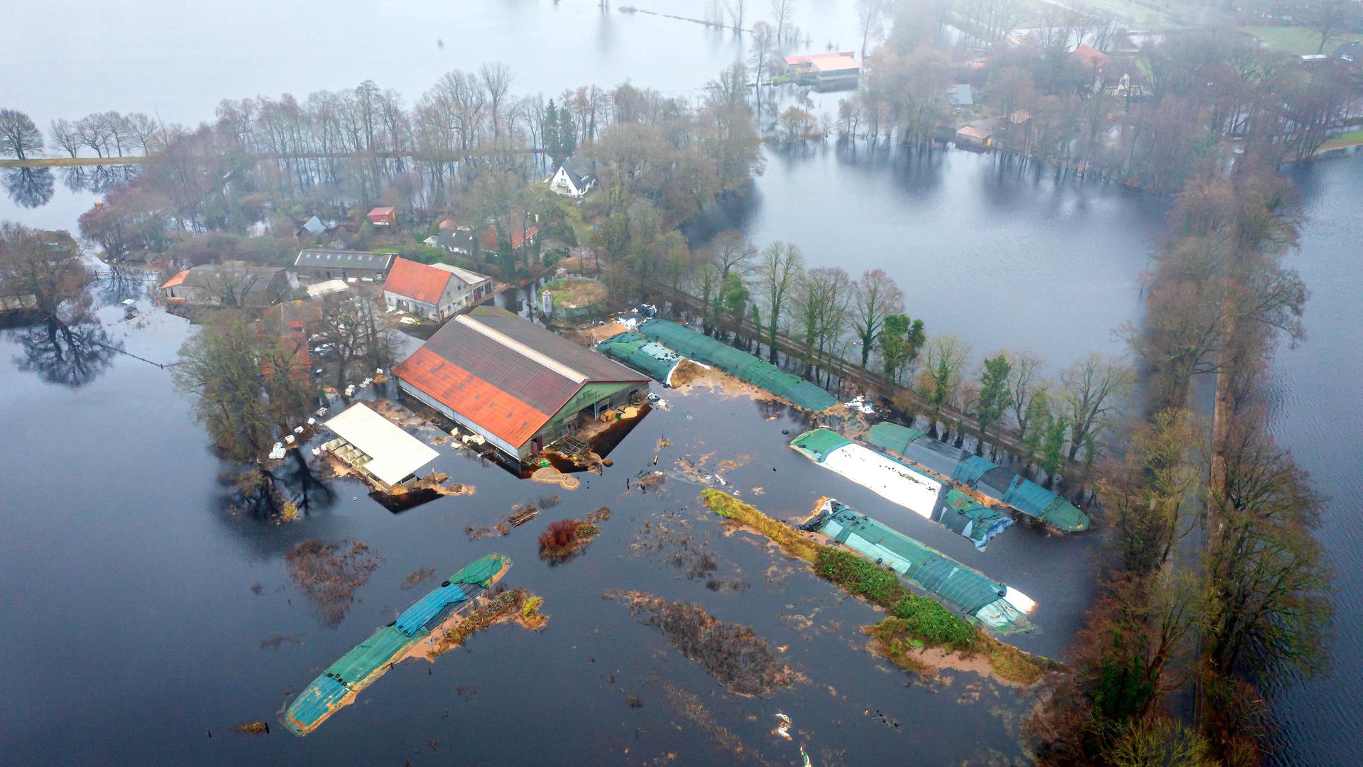 Luftaufnahme mit einer Drohne: Ein Bauernhof steht unter Wasser.