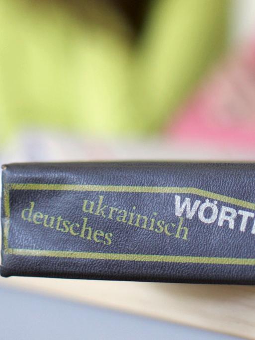 Ein Wörterbuch der deutschen und ukrainischen Sprache liegt auf einem Tisch 