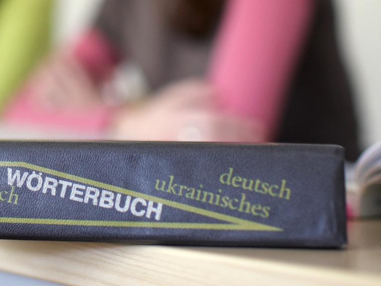 Ein Wörterbuch der deutschen und ukrainischen Sprache liegt auf einem Tisch 