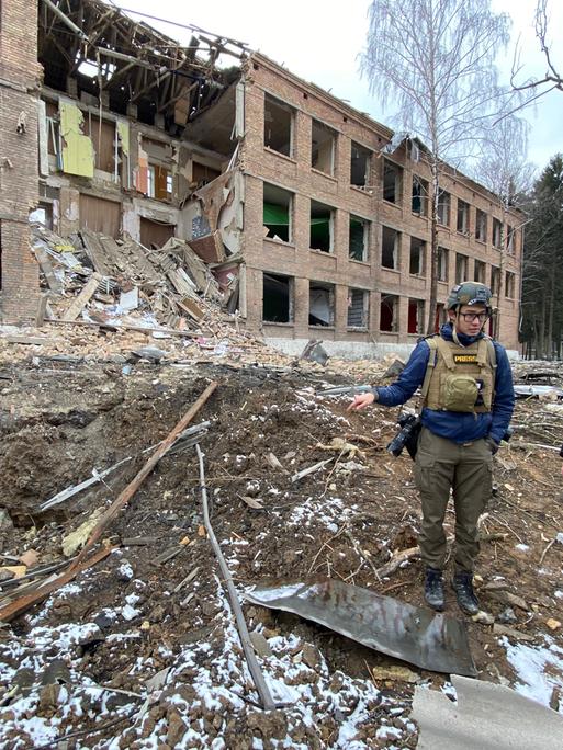 Zwei Journalisten stehen im ukrainischen Wassylkiw (bei Kiew) vor einem zerstörten Gebäude - eine Agenturaufnahme
