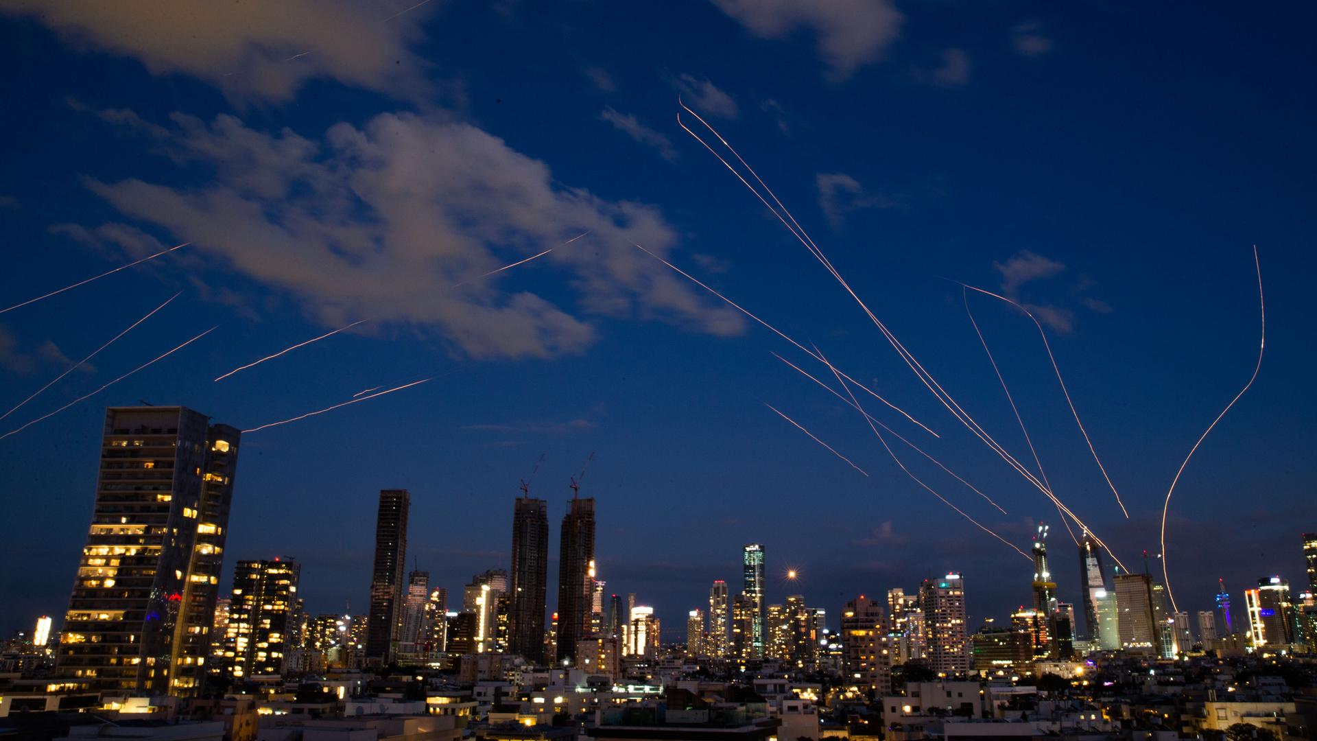Diese Langzeitbelichtung zeigt die Skyline von Tel Aviv bei Nacht mit Leuchtspuren von Abfangraketen, die von israelischen Luftverteidigungssystemen in Tel Aviv abgefeuert wurden.