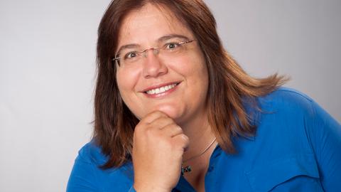 Die Evolutionsbiologin Susanne Foitzik hält ihre rechte Hand ans Kinn und blickt freundlich in die Kamera. Sie trägt ein blaues Hemd, eine randlose Brille und hat braune, halblange Haare.