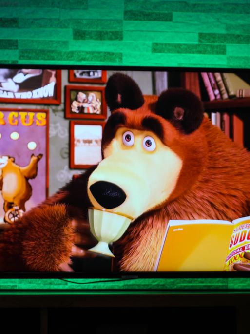  Auf dem Fernsehbildschirm ist die russische Zeichentrickserie für Kinder „Mascha und der Bär“ zu sehen.