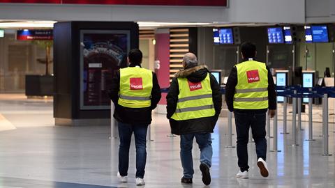 Nordrhein-Westfalen, Düsseldorf: Männer in Verdi-Westen gehen durch den Flughafen in Düsseldorf. Die Gewerkschaft Verdi hat ihre Mitglieder zu Warnstreiks an den nordrhein-westfälischen Flughäfen und im öffentlichen Dienst aufgerufen.