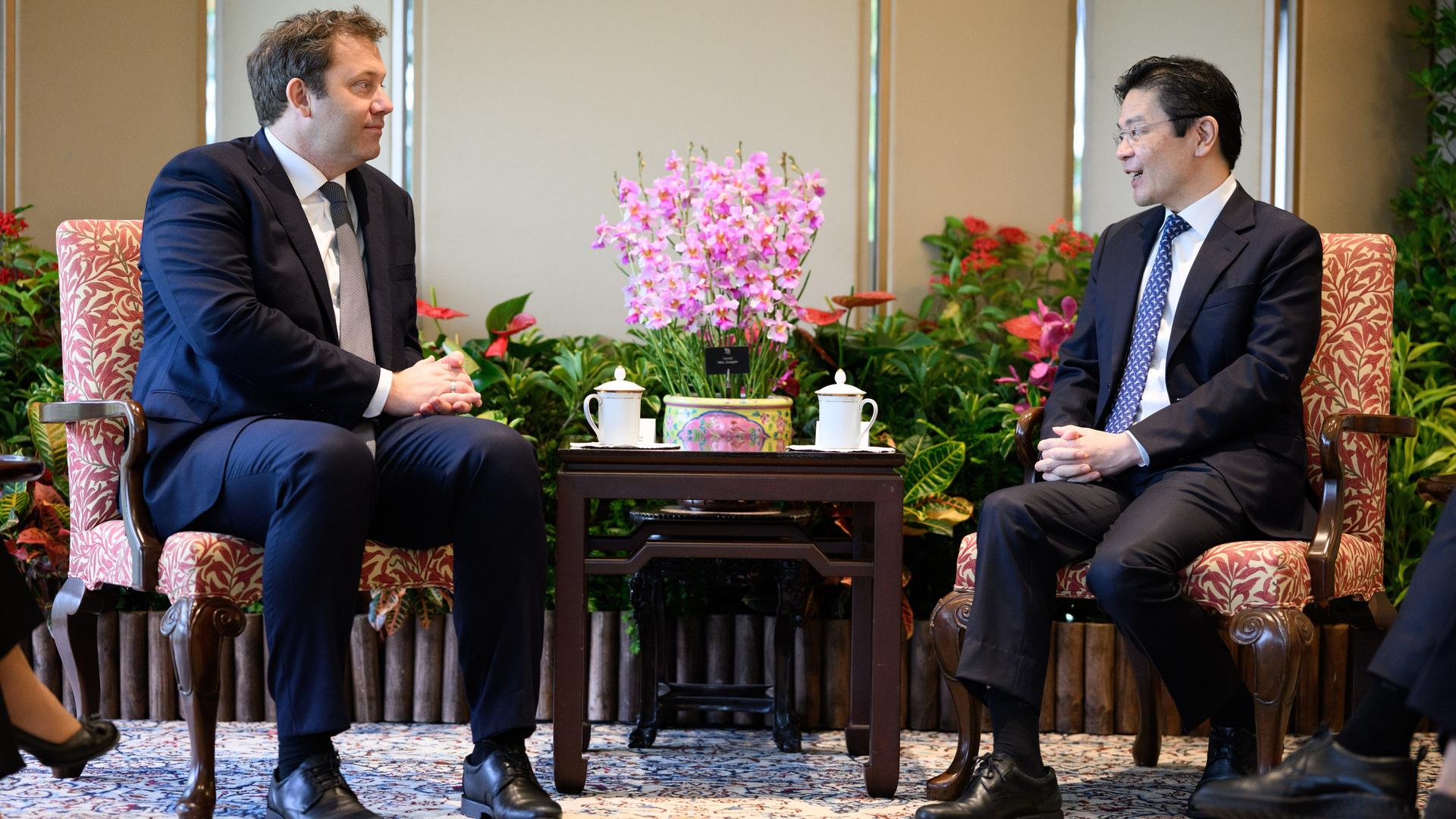 Lars Klingbeil und Lawrence Wong sitzen sich an einem kleinen Tisch gegenüber. 