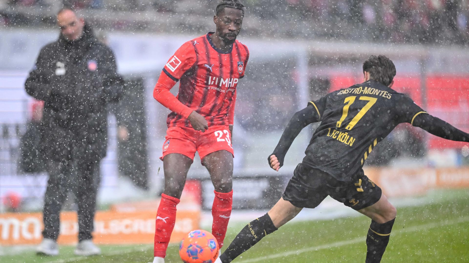 Im dichten Schneetreiben kämpfen beide Spieler um den Ball, der orangefarben ist, um besser erkannt zu werden. Im dichten Schneetreiben kämpfen beide Spieler um den Ball, der orangefarben ist, um besser erkannt zu werden.