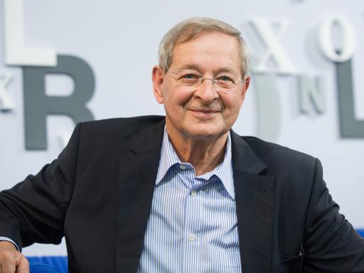 Der ungarische Schriftsteller Péter Nádas sitzt auf einem blauen Sofa Der ungarische Schriftsteller Péter Nádas sitzt auf einem blauen Sofa