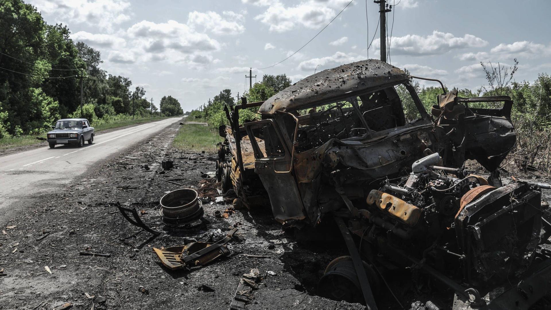 Russland, Belgorod, Region Kozinka: Ein zerstörtes Fahrzeug steht an einer Straße.
