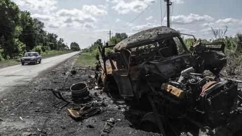 Russland, Belgorod, Region Kozinka: Ein zerstörtes Fahrzeug steht am einer Straße.