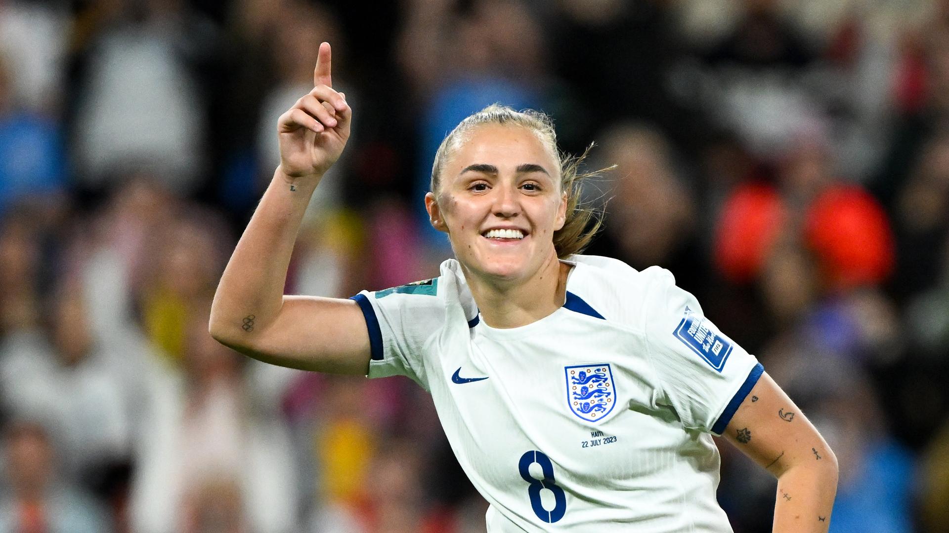 Die englische Fußball-Nationalspielerin Georgia Stanway reckt den rechten Zeigefinger in die Luft und lacht. Die englische Fußball-Nationalspielerin Georgia Stanway reckt den rechten Zeigefinger in die Luft und lacht.