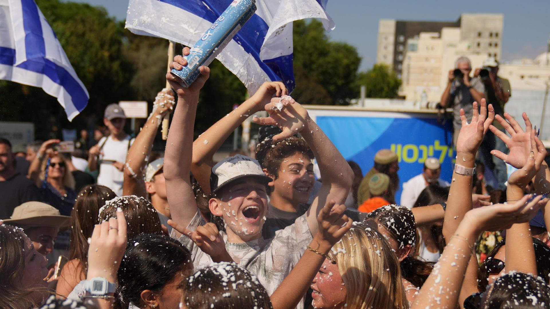 Menschen schwenken israelische Flaggen und versprühen Schaum nach der Ankunft der befreiten Geiseln im Beilinson-Krankenhaus in Petah Tikva. Menschen schwenken israelische Flaggen und versprühen Schaum nach der Ankunft der befreiten Geiseln im Beilinson-Krankenhaus in Petah Tikva.