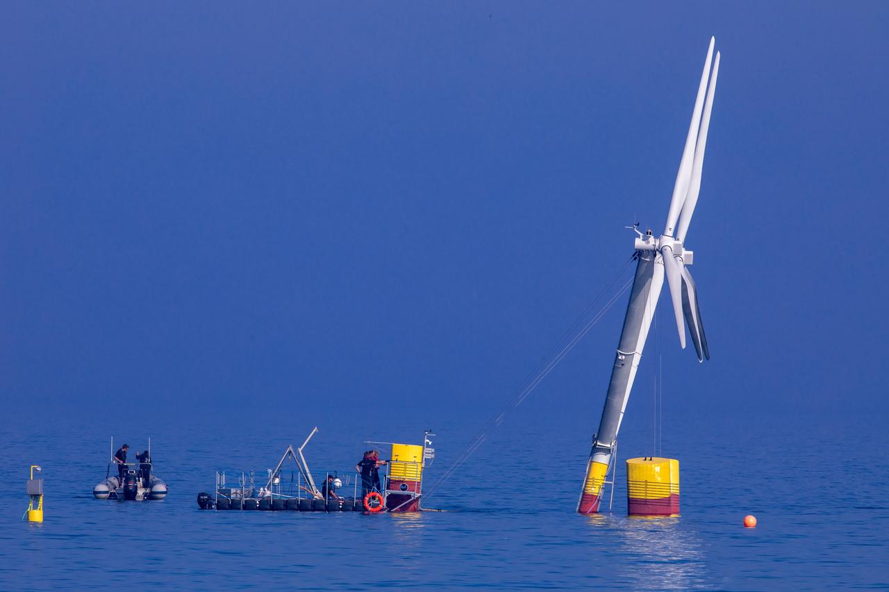 Monteure verankern eine 18 Meter hohe Anlage mit schwimmenden Windrädern im Greifswalder Bodden. Bisher sind Off-Shore-Anlagen fest auf Stahlgestellen im Meeresgrund verankert. Im späteren Regelbetrieb auf dem Meer sollen die Windräder eine Höhe von 180 Metern aufweisen.