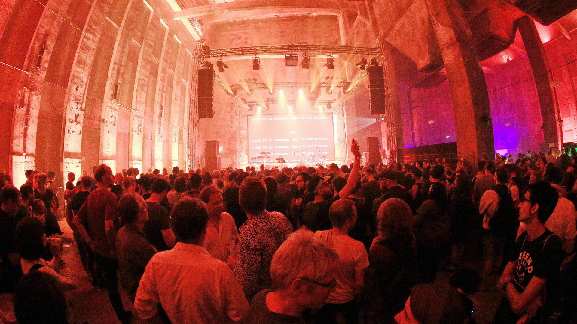 Der Club Berghain in Kreuzberg mit Publikum vor der beleuchteten Bühne