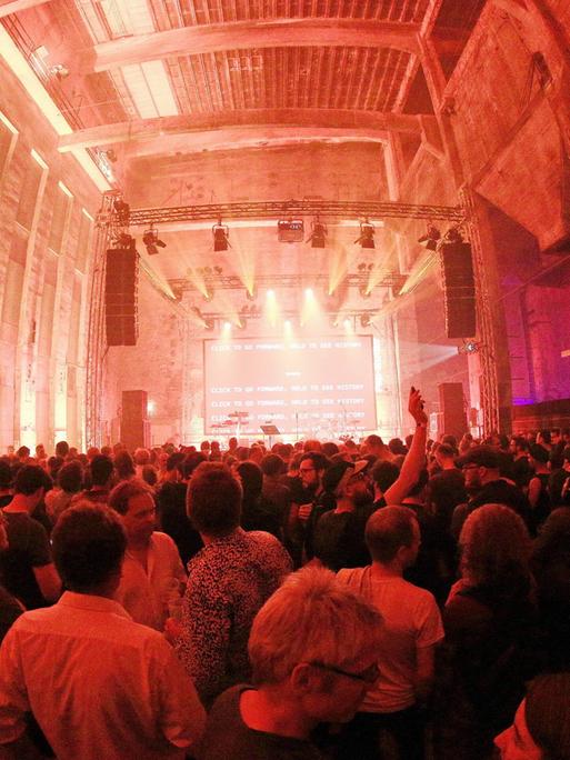 Der Club Berghain in Kreuzberg mit Publikum vor der beleuchteten Bühne