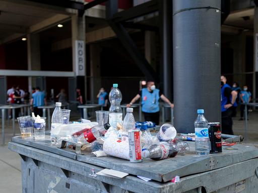 Abfall sammelt sich auf einer Mülltonne vor dem Stadion.
