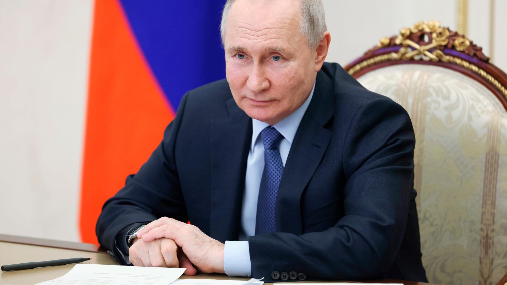 Wladimir Putin sitzt an einem Schreibtisch und hat Papiere vor sich liegen. Wladimir Putin sitzt an einem Schreibtisch und hat Papiere vor sich liegen.