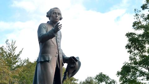 Ein Standbild des Philosophen Immanuel Kant zeichnet sich gegen den Himmel ab.