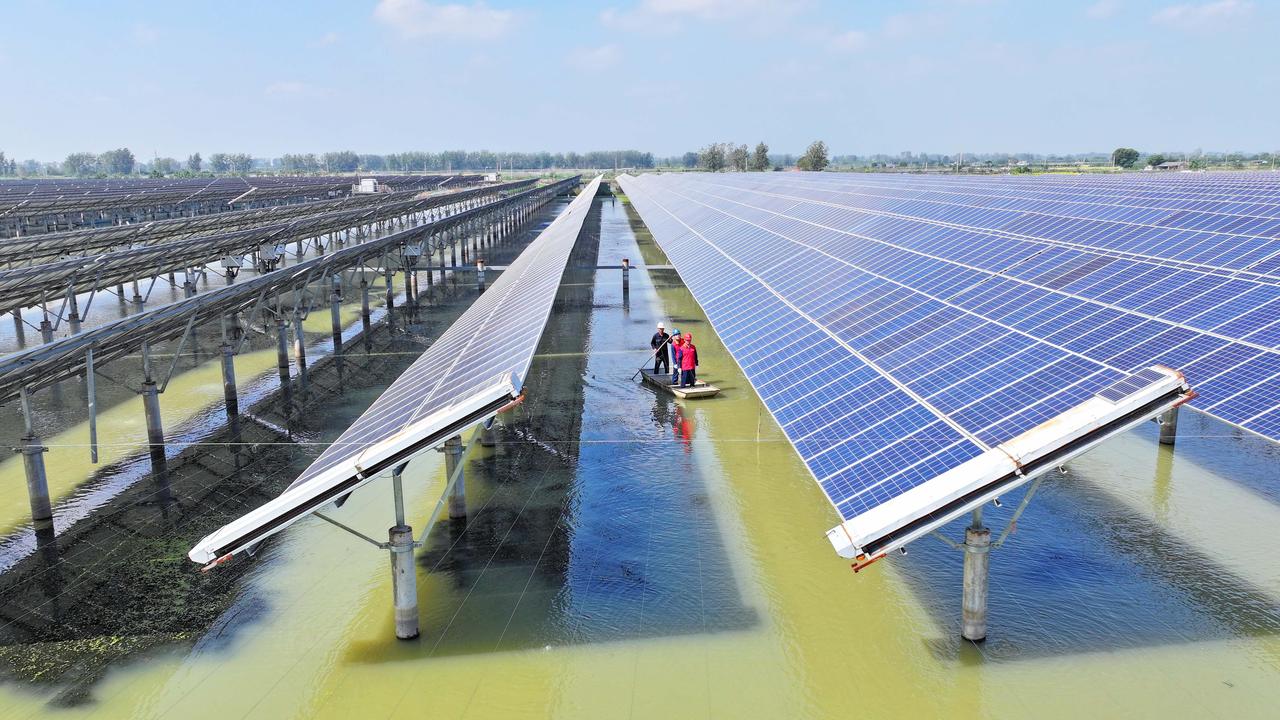 Solarmodule sind in langen Reihen über einem See installiert. Solarmodule sind in langen Reihen über einem See installiert.