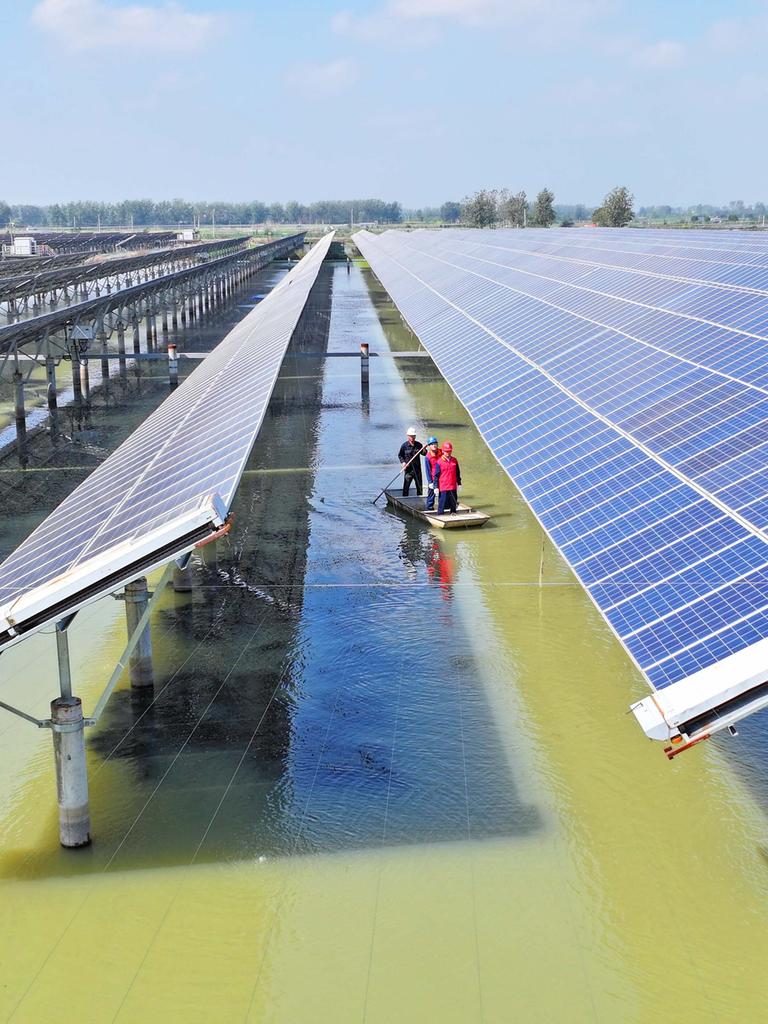 Solarmodule sind in langen Reihen über einem See installiert. Solarmodule sind in langen Reihen über einem See installiert.