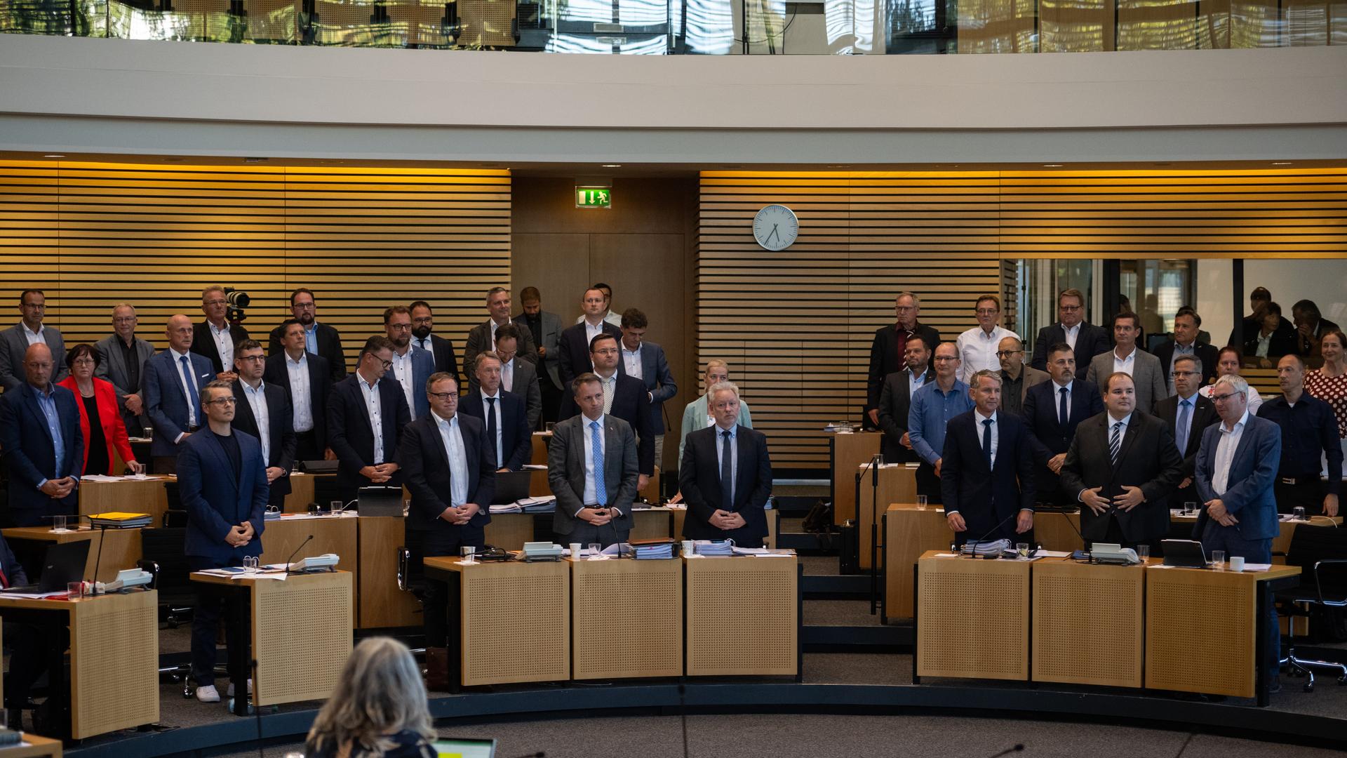 Die Abgeordneten von FDP, CDU und AfD stehen im Plenarsaal des Thüringer Landtages an ihren Plätzen und stimmen damit für das Gesetz zur Senkung der Grunderwerbsteuer.