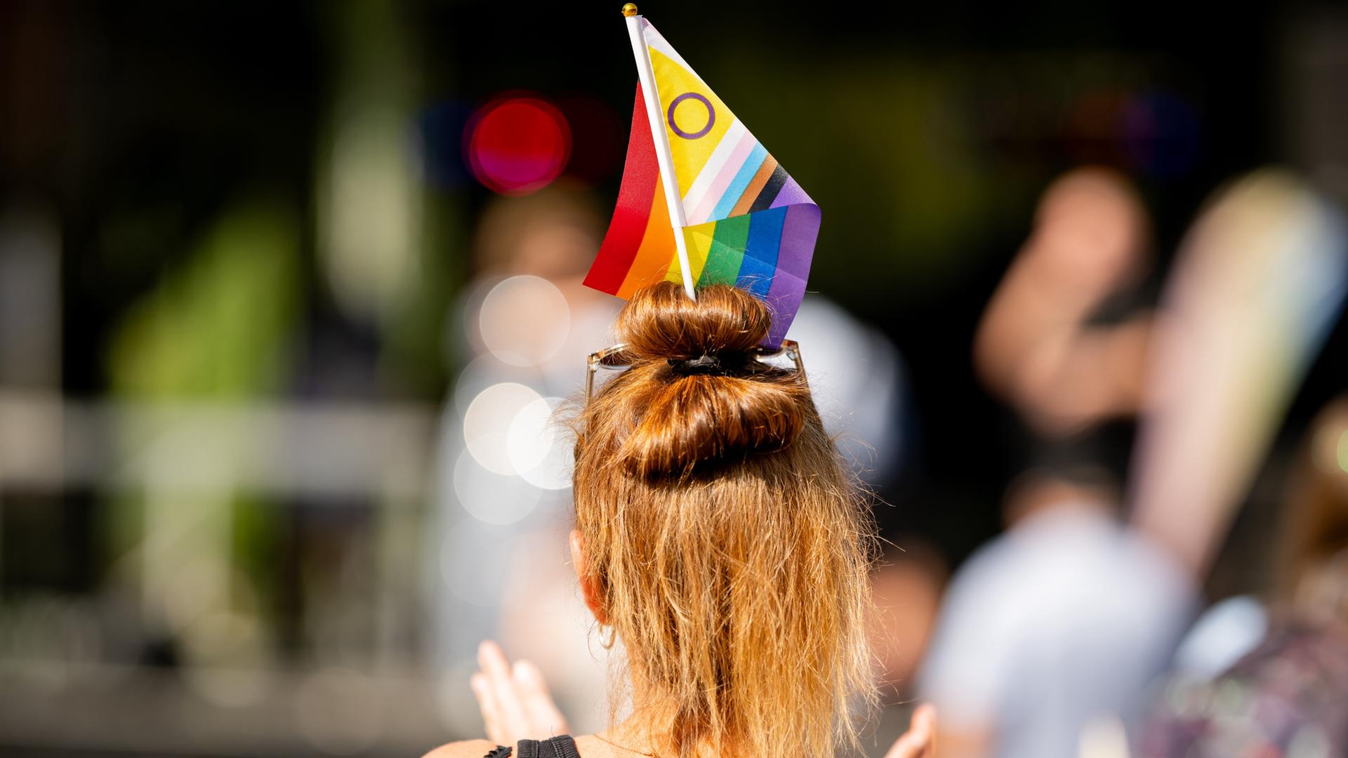 Eine Teilnehmerin mit einer Inter*Progress-Flag in den Haaren geht beim Christopher Street Day (CSD) in Thüringen durch die Innenstadt. 