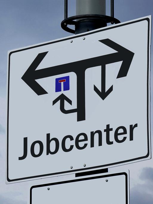Ein Wegweiser in Brandenburg zeigt den verwirrenden Weg zu einem Jobcenter an.