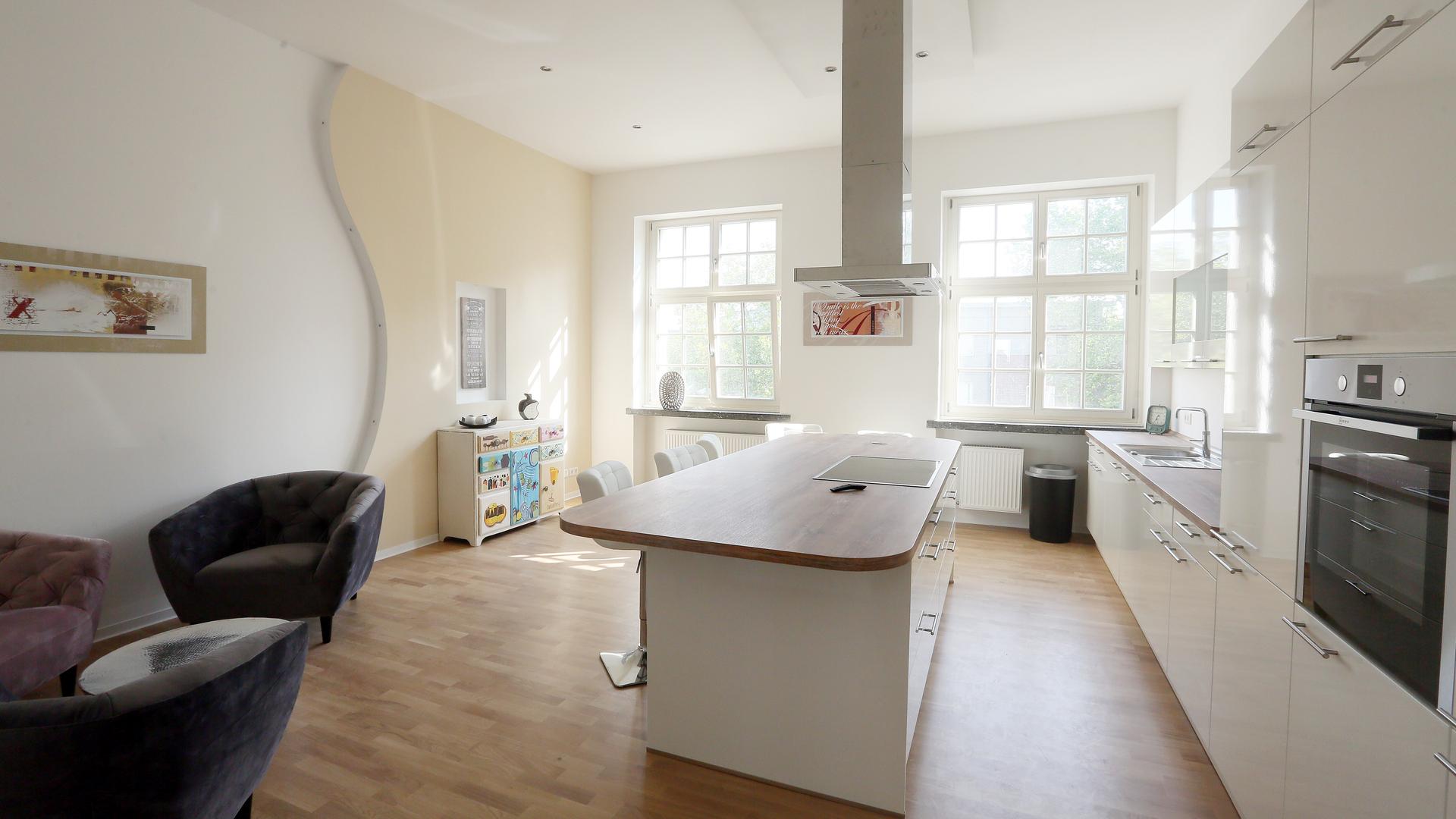 Eine möblierte Wohnung. Die Möbel sind weiß und schwarz und sehr sauber.