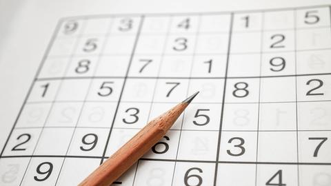 Zu sehen Logikrätsel Sudoku mit einem Bleistift. Ziffern auf Quadraten. Aus dem japanischen bedeutet es wörtlich so viel wie Ziffern dürfen nur einmal vorkommen.