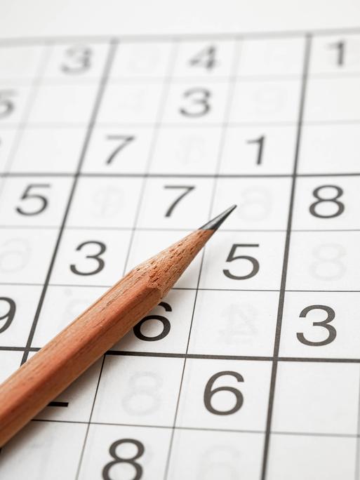 Zu sehen Logikrätsel Sudoku mit einem Bleistift. Ziffern auf Quadraten. Aus dem japanischen bedeutet es wörtlich so viel wie Ziffern dürfen nur einmal vorkommen.