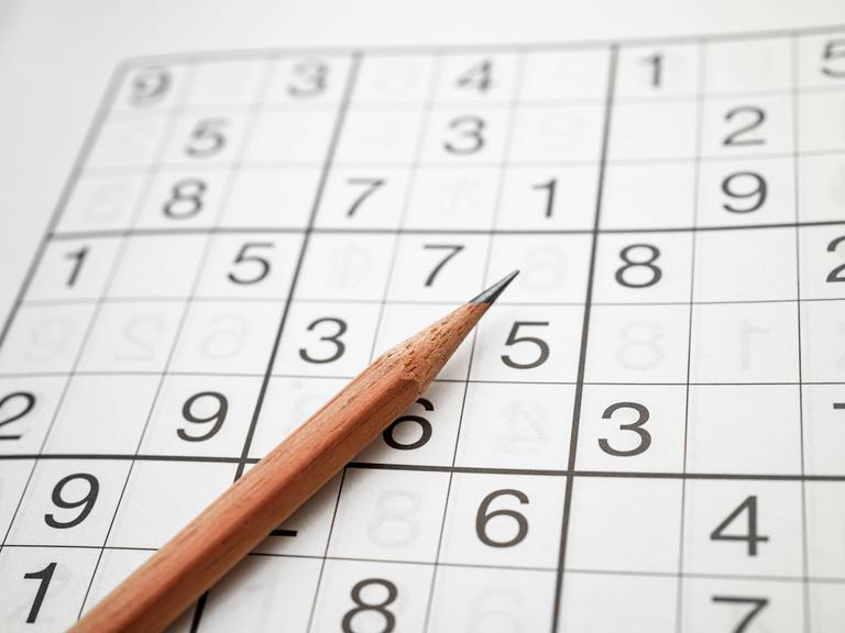 Zu sehen Logikrätsel Sudoku mit einem Bleistift. Ziffern auf Quadraten. Aus dem japanischen bedeutet es wörtlich so viel wie Ziffern dürfen nur einmal vorkommen.